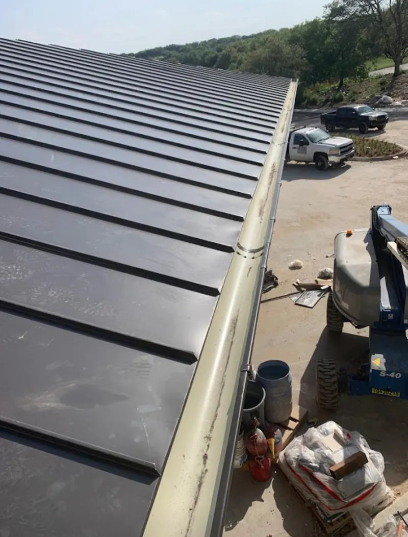 Standing seam panel and gutter detail on a metal roofing jobsite in Nampa
